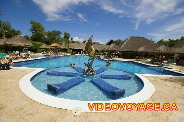 Mexique Playa del Carmen Riu Lupita Des chaises longues dans la piscine autour d'une statue.