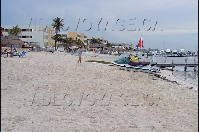 Mexique Cancun Aquamarina Beach Une terrasse près de la plage avec plusieurs chaises longues et un abri pour le soleil.