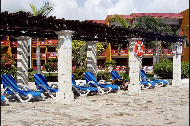 Mexique Cancun Carrousel Some fabric-covered chairs around the pool. There is no umbrella but rather a type of shelters that do not actually protect from the sun.