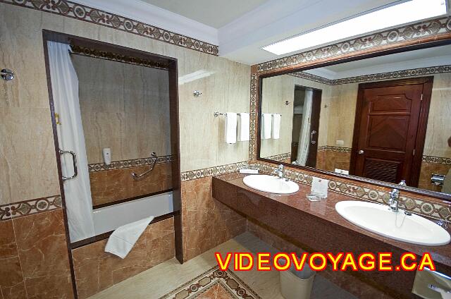 Mexique Cancun Riu Palace Las Americas A counter in the bathroom with 2 sinks. Left bath / shower with a soap dispenser.