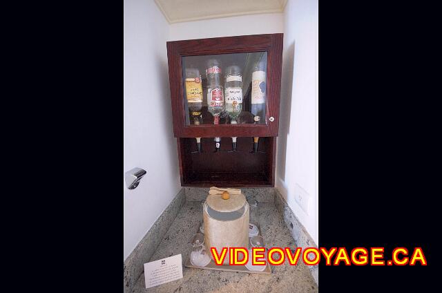 Mexique Cancun Riu Palace Las Americas El mini bar con 4 botellas de licor y un refrigerador.