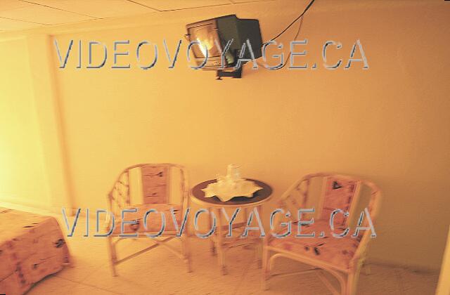 Cuba Guardalavaca Club Amigo Atlantico Guardalavaca Una pequeña mesa con dos sillas y TV en la pared.