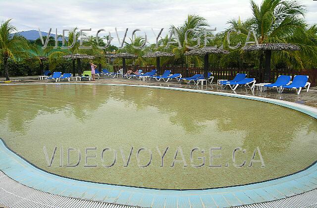 Cuba Guardalavaca Blau Costa Verde La piscina cuenta con tres sucursales, aquí la parte más remota del hotel. Paraguas, sombrillas y sillas con tejido de una pequeña terraza amplia.