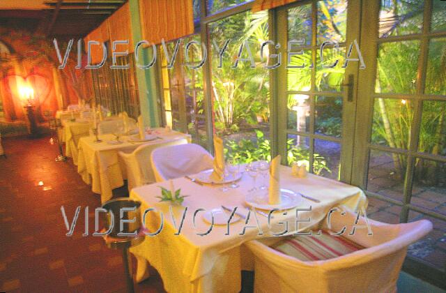 Cuba Guardalavaca Paradisus Rio de oro The tables at the back of the restaurant with a view of a garden.