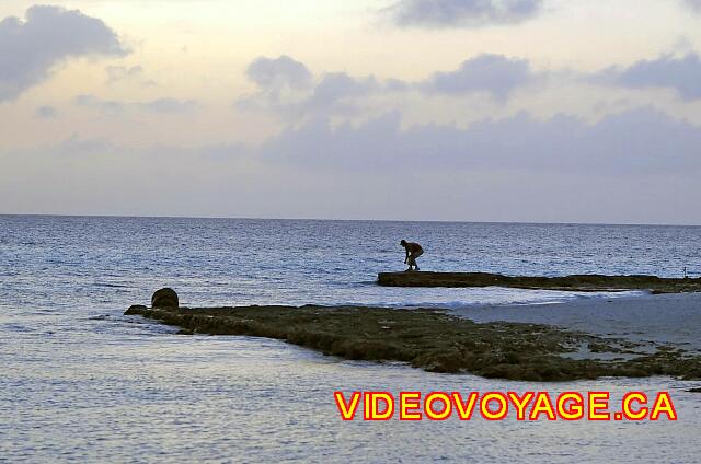 Cuba Guardalavaca Playa Pesquero A Cuban who on the rocky point fishing at sunset.