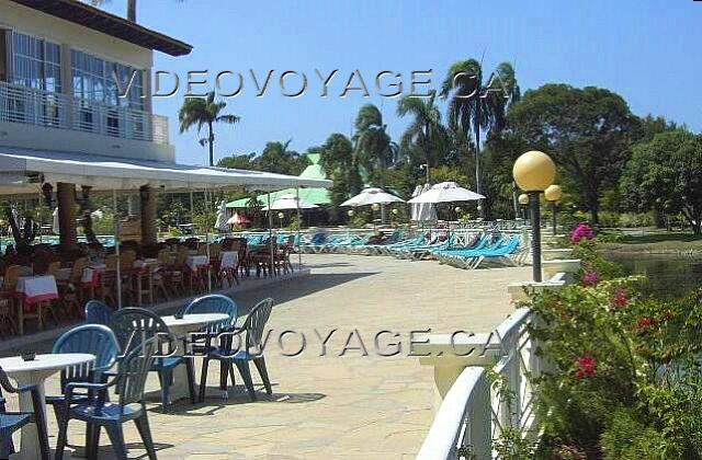 Republique Dominicaine Puerto Plata Victoria Resorts Vue de la terrasse. La terrasse de l'hôtel longe le lac.  Pour certains souper, un grill est installé sur cette terrasse.  Une magnifique vue du terrain de golf. Au fond de la photographie, on peut voir le toit vert du club house du terrain de golf.