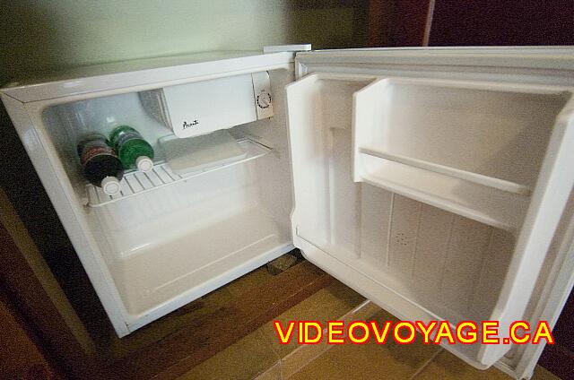 Republique Dominicaine Puerto Plata Viva Playa Dorada A fridge with a freezer section and two bottles of soft drinks.