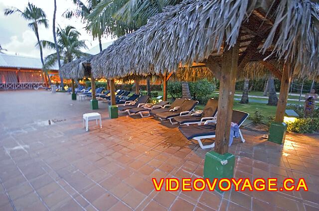 Republique Dominicaine Punta Cana Barcelo Bavaro Caribe Some chairs under palapas for shade from the sun. The chairs have a cushion under the palapas.