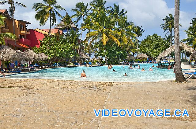 Republique Dominicaine Punta Cana Club Caribe Con una gran terraza alrededor de la piscina, un montón de sillas y palapas.