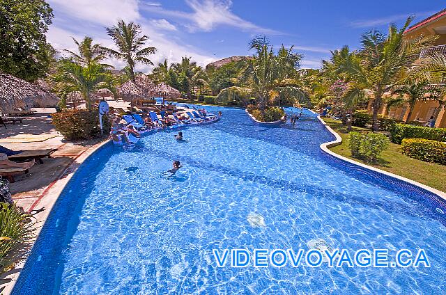 République Dominicaine Punta Cana Dreams Punta Cana Derecha, una sección de la piscina que sigue antes de un edificio que habritent habitaciones.