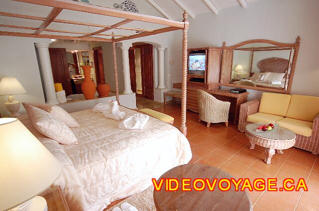 Republique Dominicaine Punta Cana Excellence Punta Cana With a sofa, small desk with mirror and TV in a cabinet.