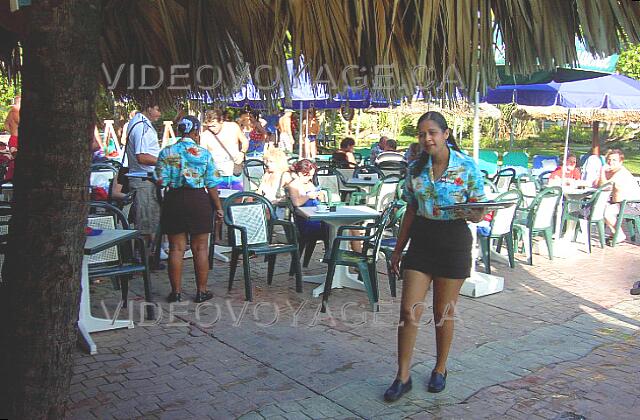 Republique Dominicaine Punta Cana Grand Palladium Bavaro Resort Le bar de la piscine possède une terrasse avec des tables qui possèdent des parasols.Beaucoup d'animation sur cette terrasse.