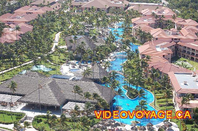 Republique Dominicaine Punta Cana Majestic Colonial Punta Cana Un vue aérienne de la longue piscine qui longe un coté de l'hôtel. Il n'y a pas de terrasse entre les chambres et la piscine car ces chambres ont un accès privé à la piscine.  La terrasse se trouve au centre car le soleil n'est pas bloqué par les batiments.
