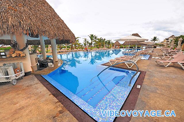 République Dominicaine Punta Cana Hard Rock Punta Cana Une piscine avec un bar dans la piscine.  Quelques parasols, plusieurs chaises longues sur la terrasse autour de la piscine.