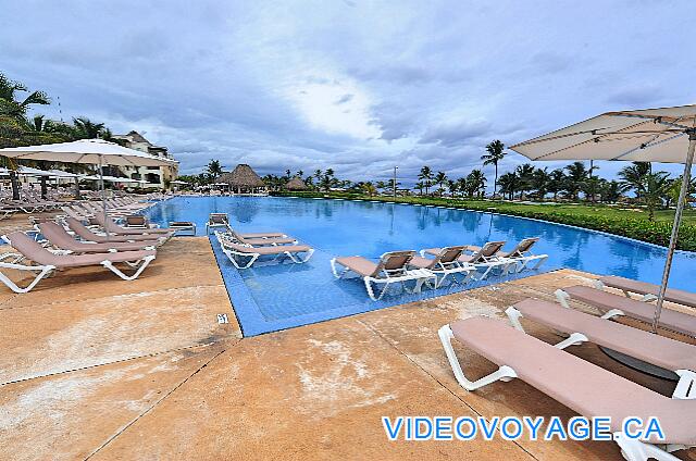 République Dominicaine Punta Cana Hard Rock Punta Cana La piscine Eclipse sur le bord de la mer, avec plusieurs chaises longues dans la piscine, plusieurs chaises longues sur la terrasse et quelques parasol.