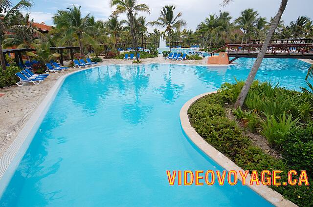 Mexique Puerto Juarez Maya Beach Dos puentes cruzan la piscina. una terraza muy grande alrededor de la piscina con un montón de tumbonas cubiertas con tejido, pero sin paraguas.