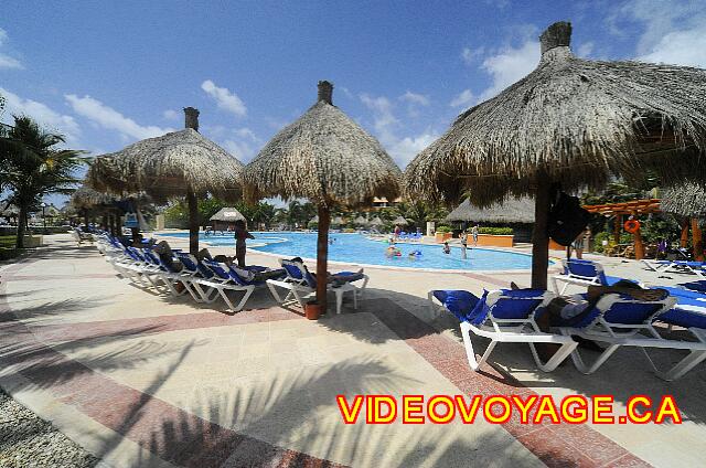 Mexique Riviera Maya Bahia Principe Tulum Las sillas y palapas en la terraza alrededor de la piscina.