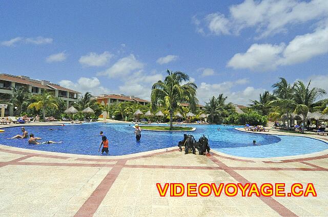 Mexique Riviera Maya Bahia Principe Coba Une grande terrasse autour, de nombreuses chaises longues et palapas, un cours d'initiation à la plongé dans la piscine, un poste de distribution des serviettes de plage,...