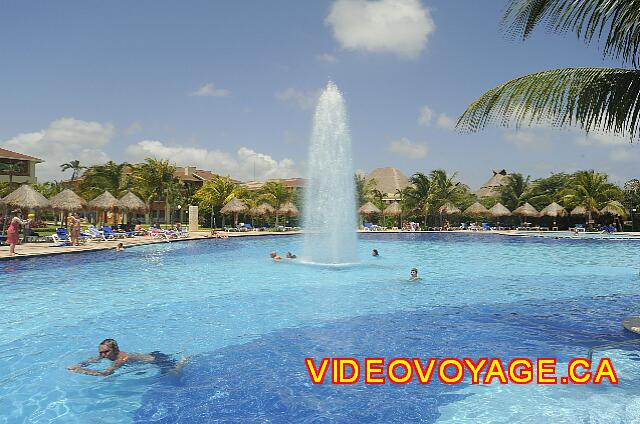 Mexique Riviera Maya Bahia Principe Coba A fountain in the center of the pool, palapas and plenty of sun loungers on the pool deck.