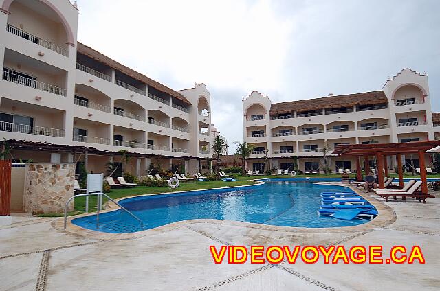 Mexique Puerto Morelos Excellence Riviera Cancun La piscina sigue los edificios de las habitaciones. Muchas sillas meu pequeñas sombrillas.