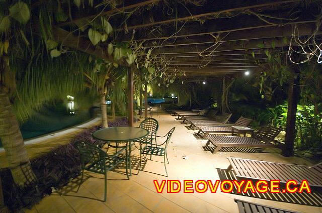 Cuba Cayo Santa Maria Iberostar Ensenachos The terrace around the pool in the evening with the sun loungers under a feuillles roof.