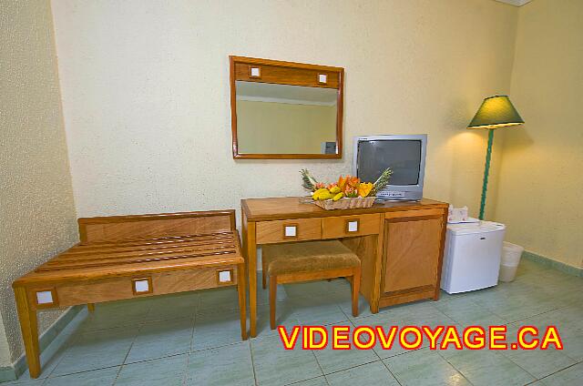 Cuba Varadero ROC Arenas Doradas Un meuble pour déposer les bagages, une maquilleuses avec un mirroir mais un manque de lumière, le téléviseur et le réfrigérateur.