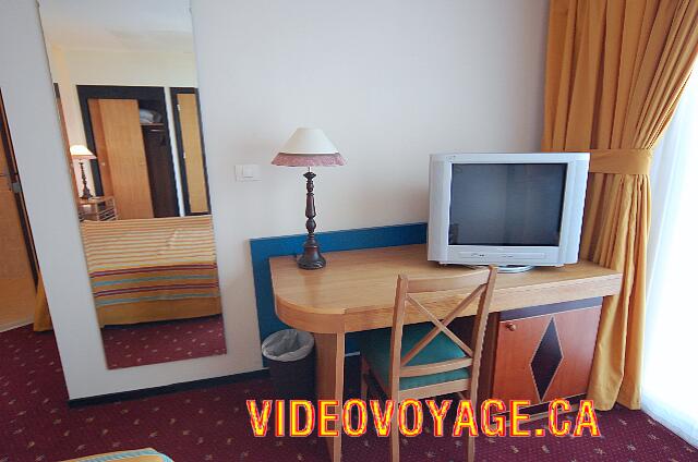 Cuba Varadero blau Varadero A TV with a swivel stand, large mirror and a cabinet with refrigerator inside.