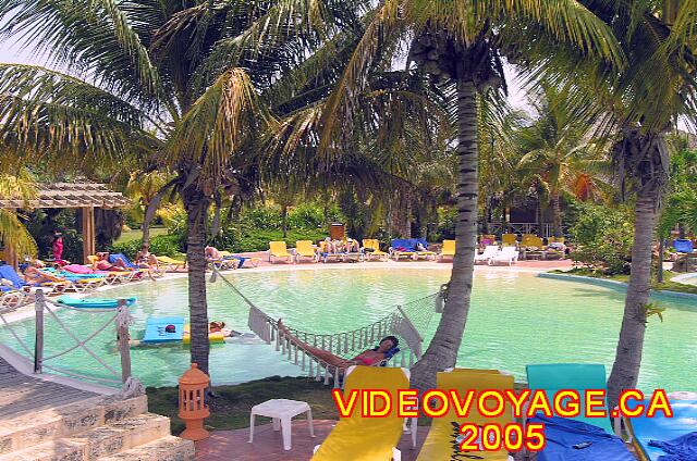 Cuba Varadero Royalton Hicacos Resort And Spa A beautiful scenery, a quiet pool, ideal for relaxing. Hammocks are arranged between palm trees on the edge of the pool.