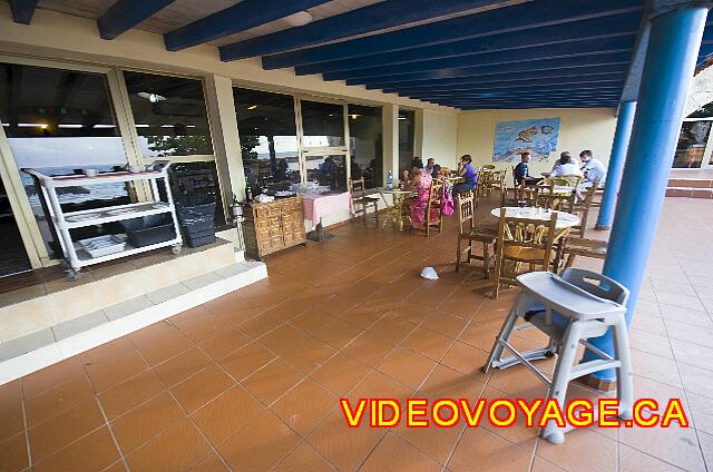 Cuba Varadero Hotel Club Kawama Quelques tables sur la terrasse extérieur ainsi qu'une chaise haute.