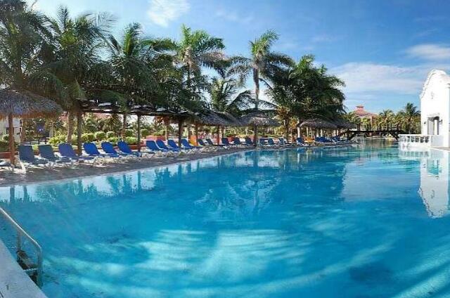 Cuba Varadero Playa Alameda Des chaises longues avec parasols sur un autre coté de la piscine, ce coté est exposé au soleil en après-midi.